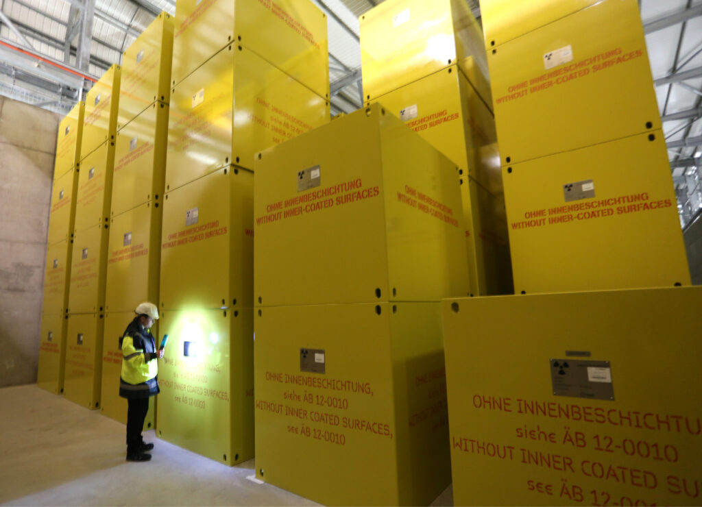 Yellow waste containers with woman standing in front of them