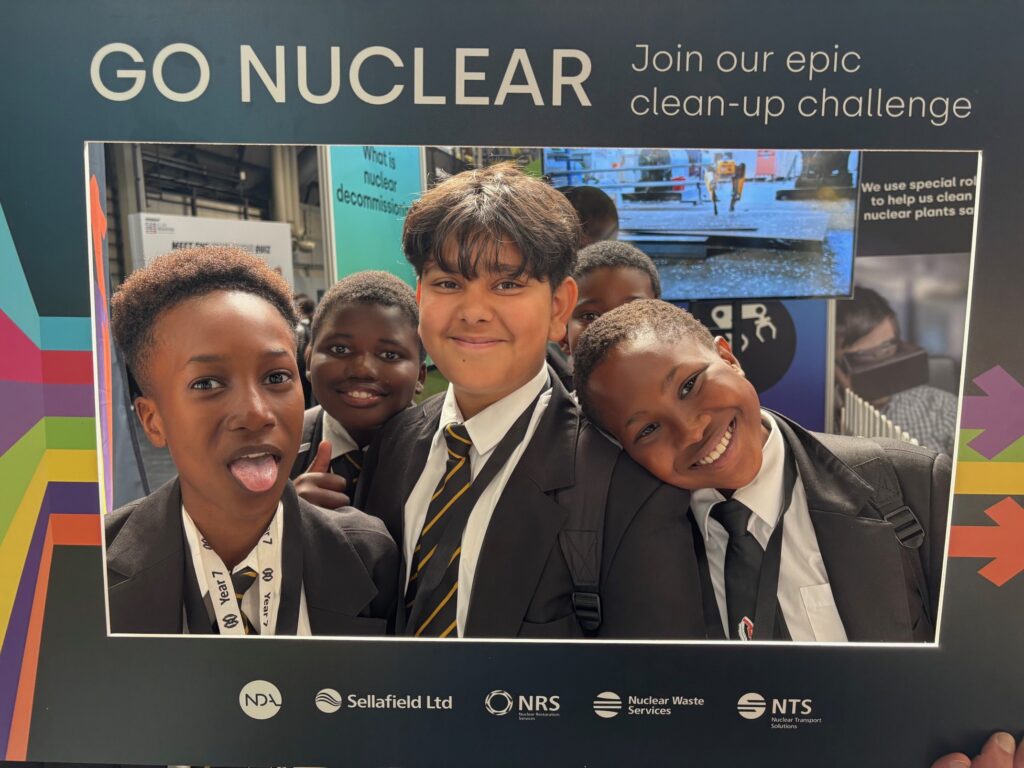Four children smiling in a sign reading "go nuclear".