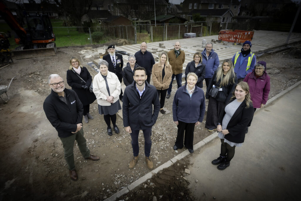 A group of people standing on site for a new Youth centre