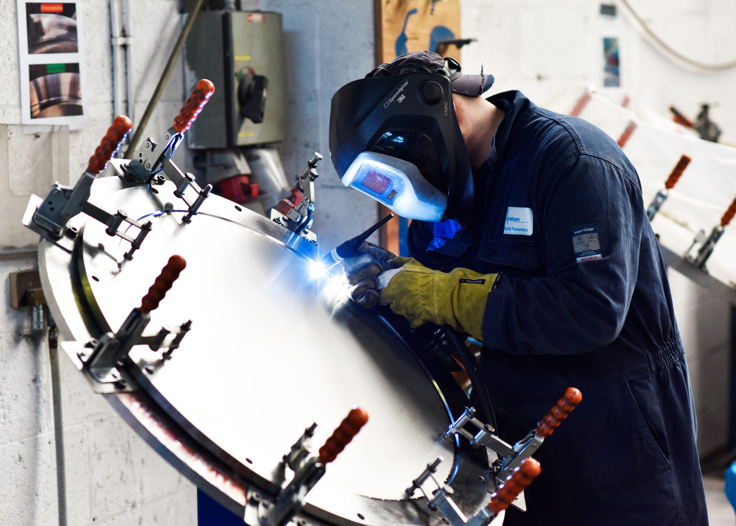 Person working on a waste container wearing a welding mask