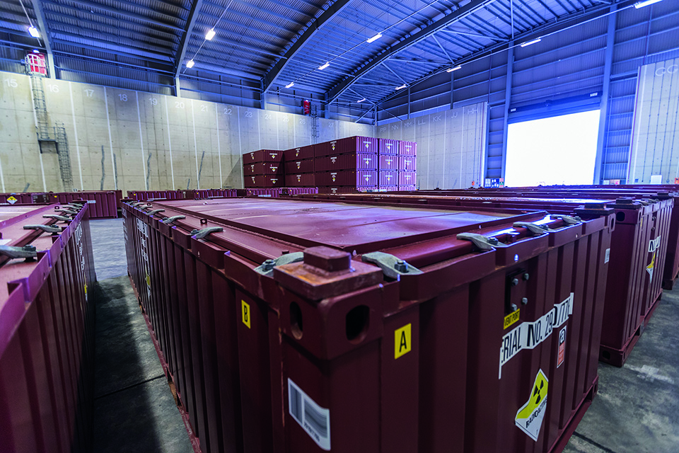 A number of red waste containers in a warehouse